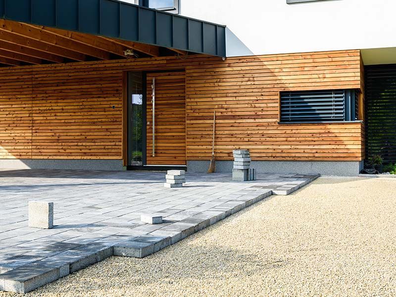 Home exterior remodel with wood siding and paver patio